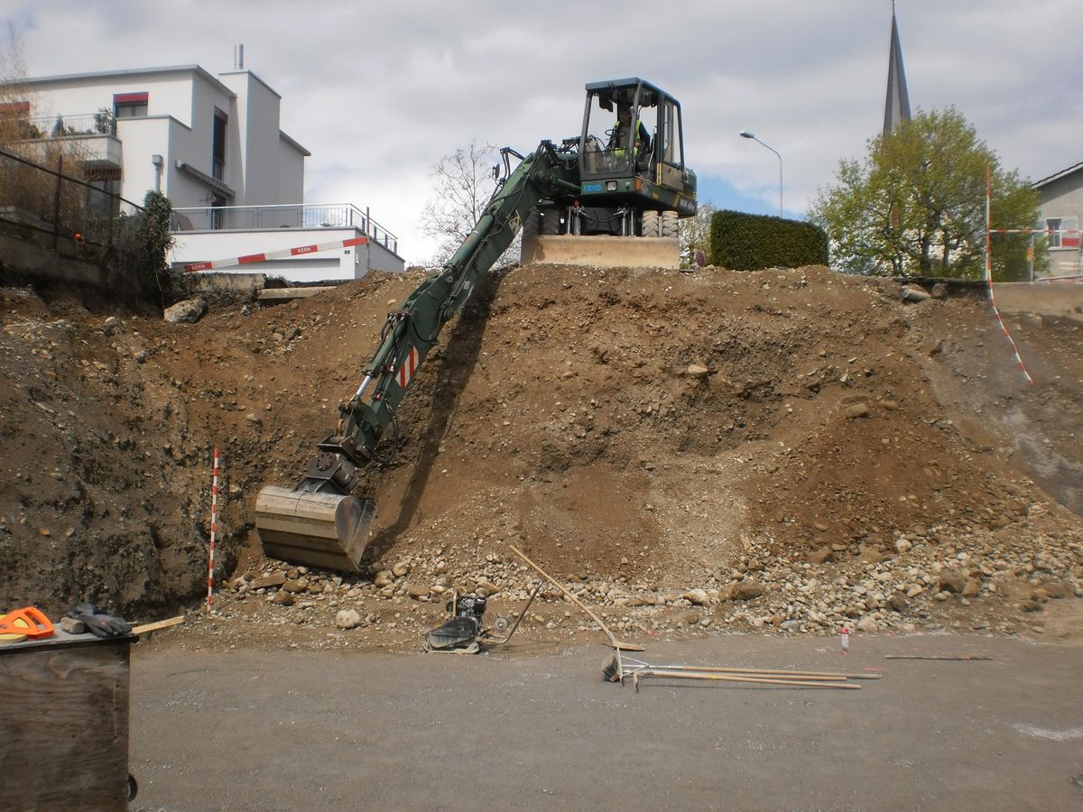 Bagger der Kern Strassenbau AG an der Böschung einer Baugrube