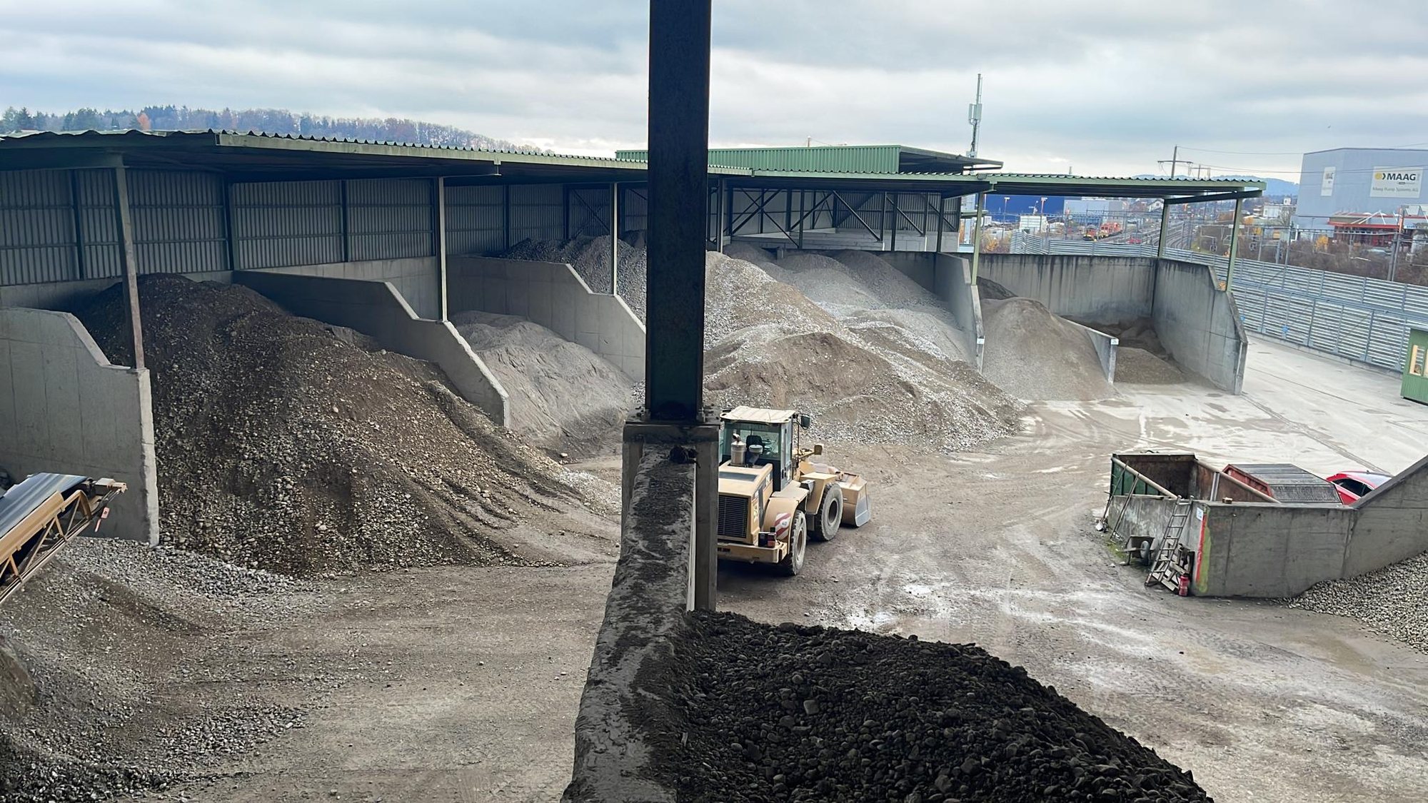 Radlader und Förderband in der Kieshalle
