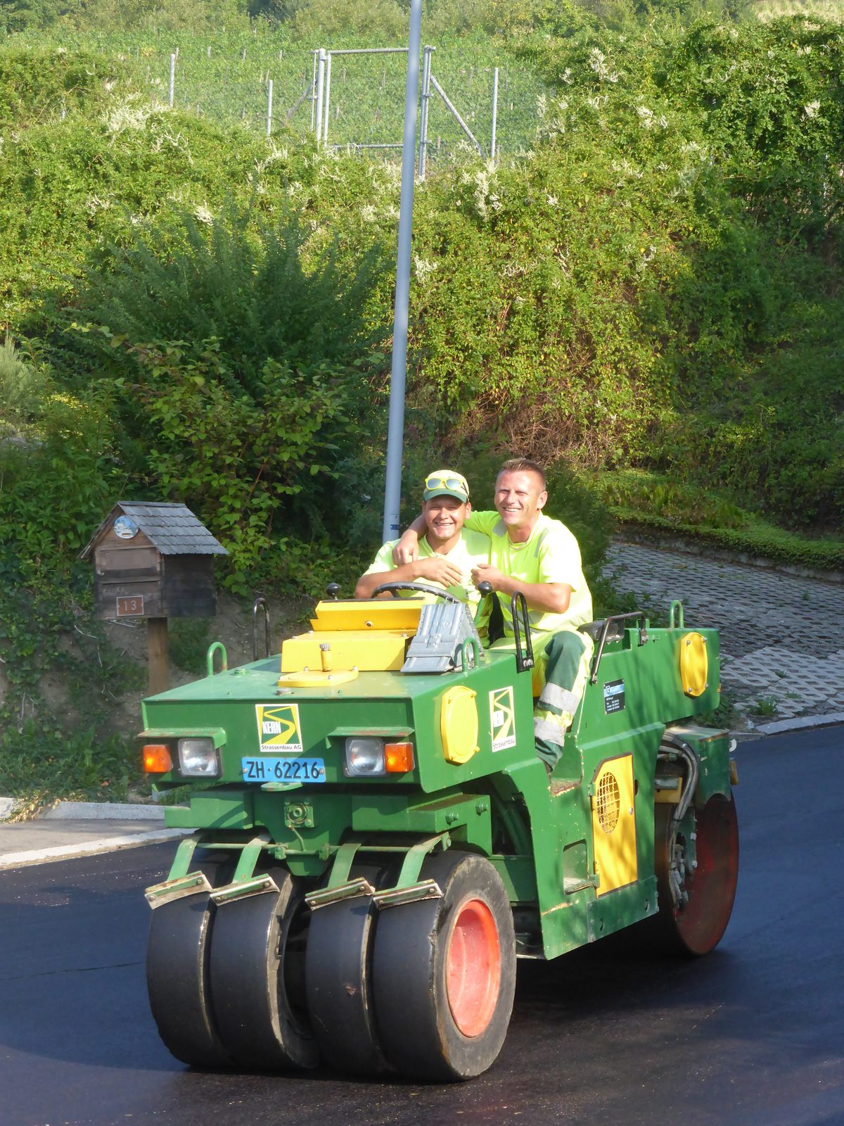 Zwei Mitarbeiter der Kern Strassenbau AG auf einer Walze